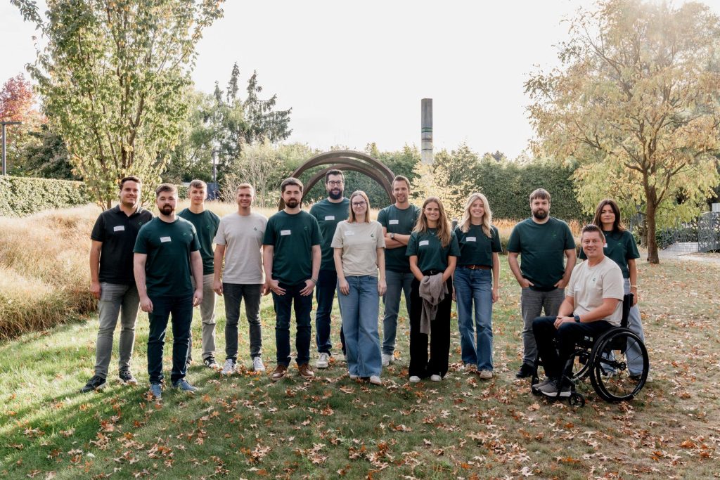 Teamleden van een digitaal marketingbureau, waaronder SEA-experten, poseren samen buiten voor een groepsfoto