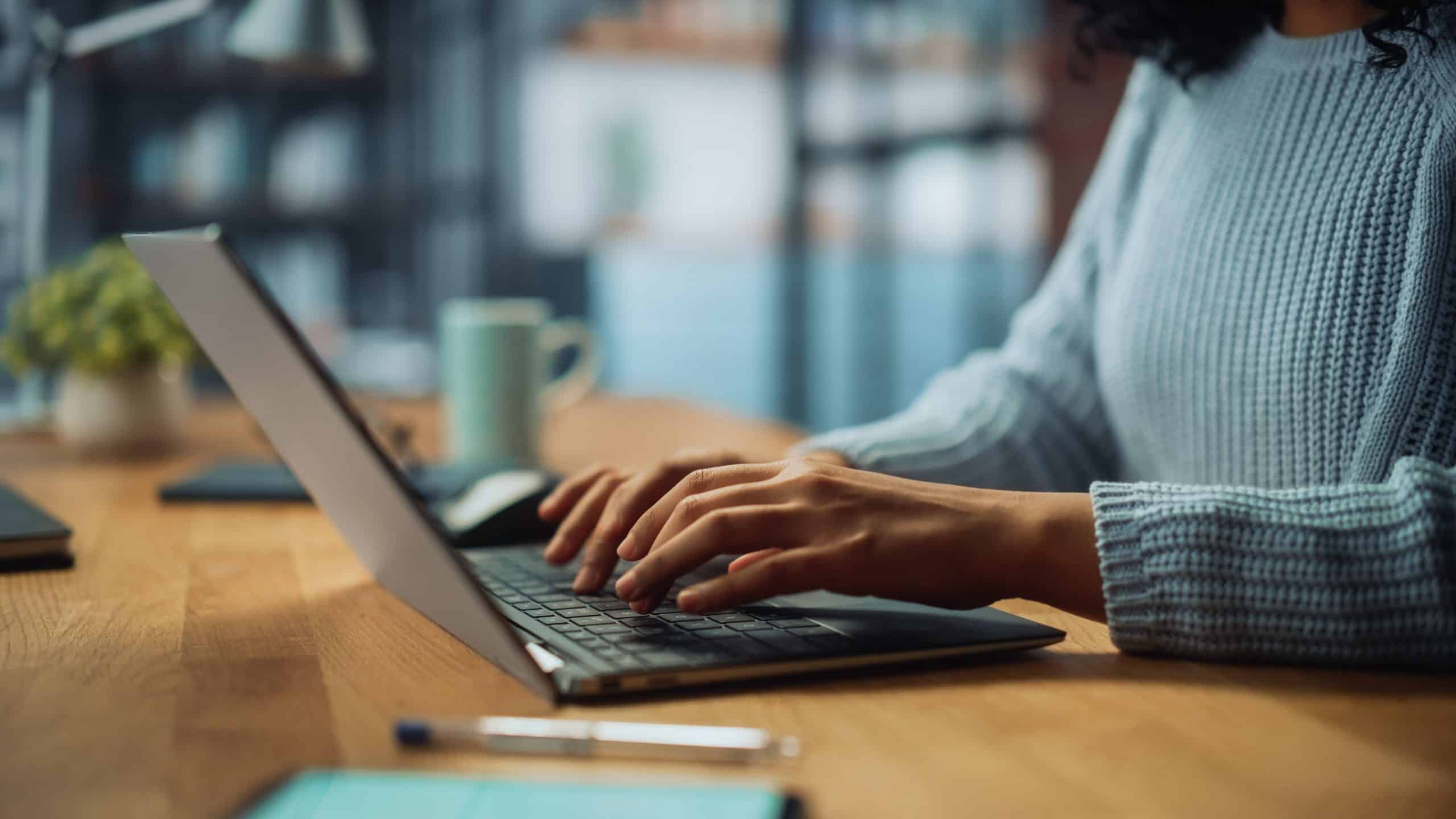 Persoon typt op laptop, illustratie van het automatiseren van e-facturatie via Peppol voor WordPress webshops.
